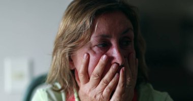 Stressed out older woman in 60s covering face with hands. Anxious worried senior woman feeling anxiety