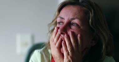 Stressed out older woman in 60s covering face with hands. Anxious worried senior woman feeling anxiety