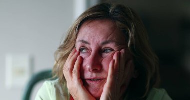 Worried older woman portrait feeling anxiety. Senior woman in 60s covering face