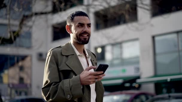 Удумлива Щаслива Людина Використовуючи Мобільний Пристрій Стоїть Міській Вулиці Слідкування — стокове відео