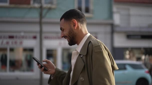 Hombre Feliz Oriente Medio Caminando Por Calle Ciudad Sosteniendo Teléfono — Vídeos de Stock