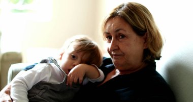 Grandmother with grandchild toddler in sofa