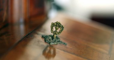 Close-up hand inserting key in antique furniture