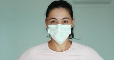Girl putting on face mask prevention against Covid 19 pandemic. Woman wearing mask against corona virus infection
