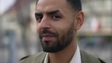 Orta Doğulu bir adamın kameraya gülümserken yakından çekilmiş görüntüsü. Sırıtan bir adamın portre resmi.