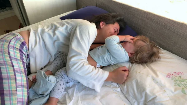 本物の母親と赤ちゃん幼児一緒にベッド抱っこ — ストック写真