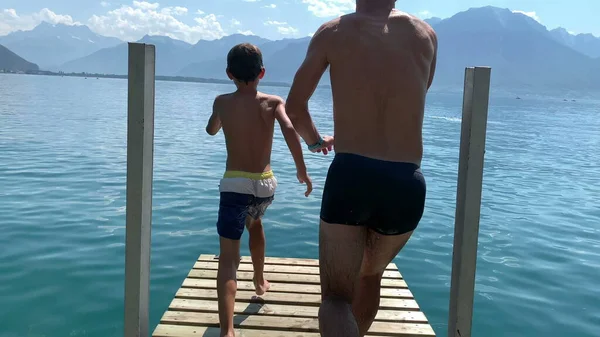 아버지와아 호수의 부두에서 뛰어내려 속으로 뛰어드는 것이다 잠수하는 — 스톡 사진