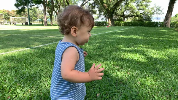 赤ん坊は屋外の芝生の上を裸足で歩く 幼児は外を歩く — ストック写真