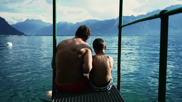 호수에 가족들 경치를 감상하고 아버지와아 갑판에 앉아서 과아름다운 바라본다 — 스톡 사진