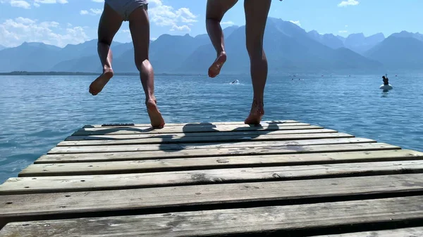 Δύο Κορίτσια Τρέχουν Στην Προβλήτα Της Λίμνης Και Πηδάνε Στο — Φωτογραφία Αρχείου