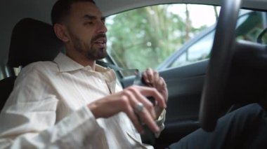 Bir Arap emniyet kemerini taktı ve uzaklaştı. Orta Doğulu bir erkek sürücü aracın içinde oturuyor ve sürüyor.