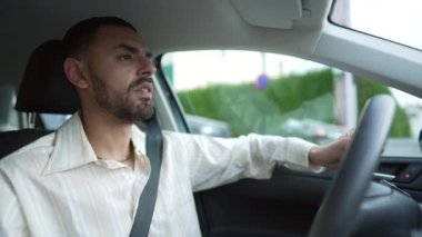 Genç bir Arap araba kullanıyor. Orta Doğulu bir Faslı erkek. Aracın içinde direksiyon tutuyor.