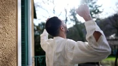 Bir gencin sırtında başarıyı kutlarken dışarıda kollarını kaldırıp Tanrı 'ya şükrediyor. Muzaffer erkek, pozitif yaşam tarzını kutluyor.