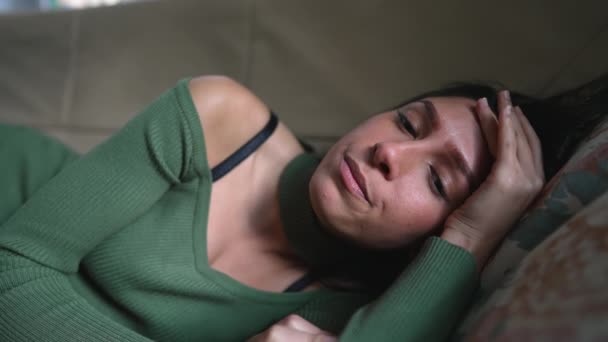 一位疲惫的 压力很大的年轻女子躺在沙发上 累了一天后感到精疲力竭 — 图库视频影像
