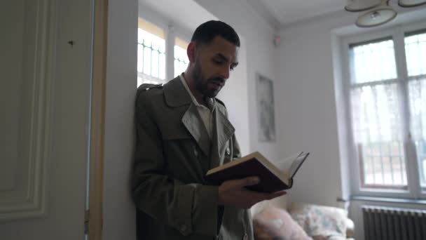 Чоловік Читає Книжку Спирається Стіну Людина Зосереджена Навчається Вдома — стокове відео