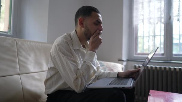 Yoğunlaşmış Bir Arap Genci Evdeki Dizüstü Bilgisayarın Önünde Içeriği Okuyor — Stok video