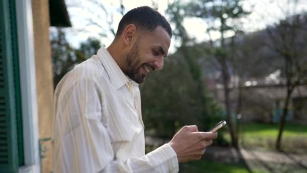Joven Árabe Feliz Gusta Mensaje Teléfono Celular Mientras Está Parado — Vídeos de Stock