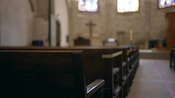 가톨릭 교회의 내부에는 의자들이 줄지어 늘어선 종교적 십자가가 — 스톡 사진