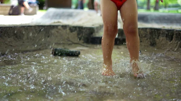 활동적 어린이는 여름날 활동중에 공원에서 물웅덩이로 뛰어드는 것이다 다물고 다리는 — 스톡 사진