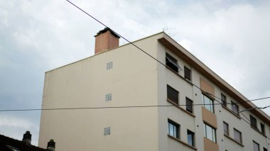 Modern düz binanın dış cephesi. Apartman dairesinin ön planda kablolarla görüntüsü alınıyor