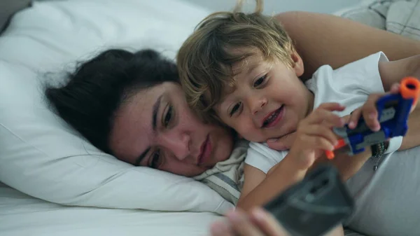 엄마와 아이들은 침대에 스마트폰 기기를 있습니다 엄마는 아이가 부모와 화면을 — 스톡 사진