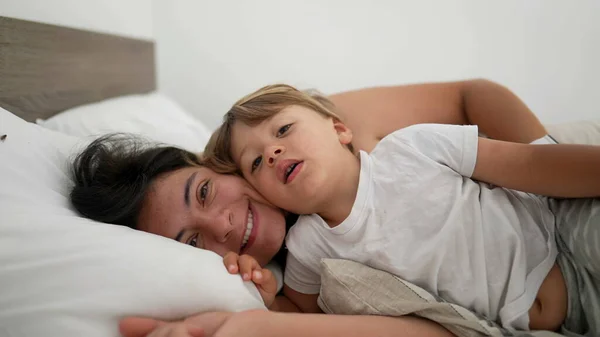 Mother Son Laid Bed Embrace Looking Camera Smiling Motherhood Lifestyle — Stock Photo, Image