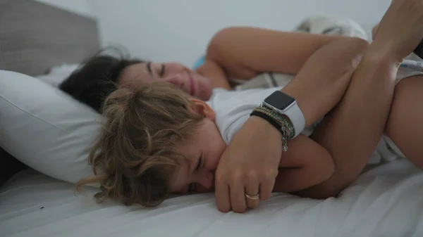 妈妈在早上的床上抱着孩子 妈妈拥抱着小男孩 真正的生活真实的生活方式家庭的爱和感情时刻 母性概念 — 图库照片