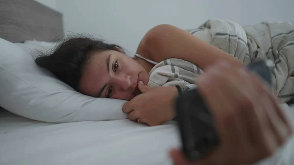 女人躺在床上 一边在网上看媒体娱乐 一边看手机内容 对技术上瘾的人 — 图库照片
