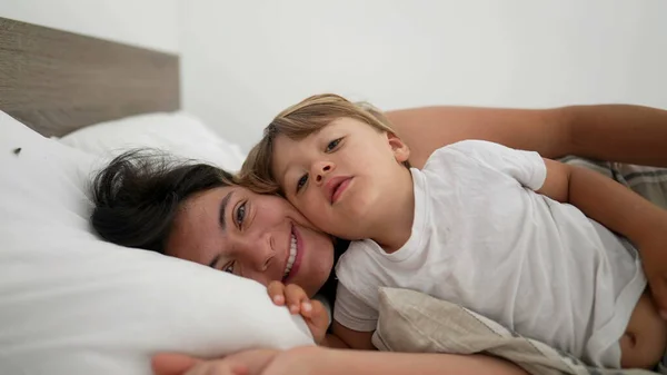 Mother Son Laid Bed Embrace Looking Camera Smiling Motherhood Lifestyle — Stock Photo, Image