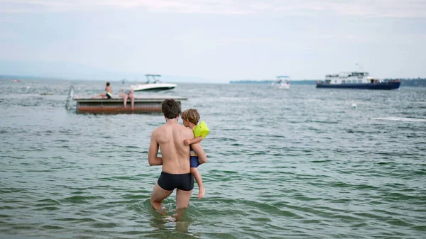 아버지는 아들을 들어간다 해변에 아이가 아버지를 보호하는 보호를 고무줄을 두르고 — 스톡 사진