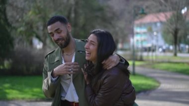 Konuşurken mutlu bir çift. Kız arkadaşı gülüyor ve erkek arkadaşı parkta dolaşırken neler söylüyor. Hakiki gülüş ve gülümseme.