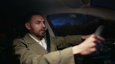 Adam endişeli bir şekilde gece araba kullanıyor. Tedirgin Ortadoğulu erkek sürücü otoyolda