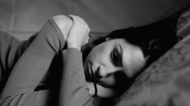 Depresyondaki yalnız yetişkin bir kız. Kapalı bir yüz. Umutsuz bir şekilde yatıyor. Monokromatik siyah-beyaz dramatik akıl hastalığından muzdarip kişi