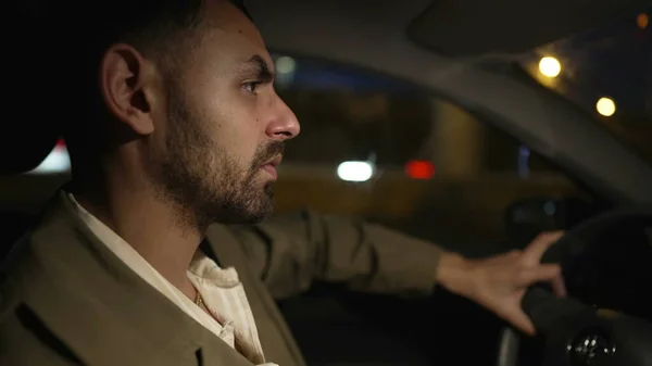 stock image Profile of a Middle Eastern person driving at night on road. Pensive Arab man inside vehicle interior