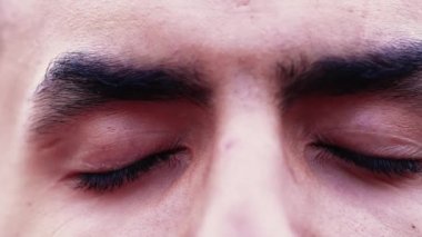 Meditasyon yapan bir Arap genci derin derin düşünüyor.