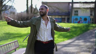 Mutlu bir Orta Doğulu adam güneşli bir günde parkta başarıyı kutluyor. Neşeli bir Arap erkeği kendinden geçmiş hissediyor.