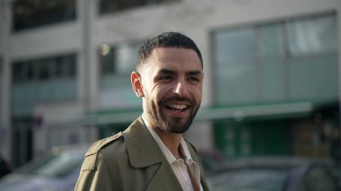 Orta Doğulu genç bir adam kameraya gülümsüyor. Neşeli bir ifadeyle Arap bir Faslı erkeğin hareket halindeki görüntüsü.