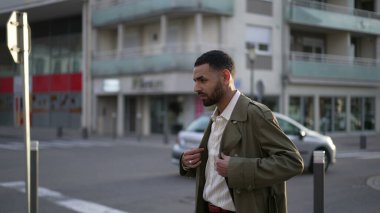 Düşünceli genç bir Arap sokakta ceketle dikiliyor. Dalgın suratlı Faslı bir adamın düşünceli ifadesi.