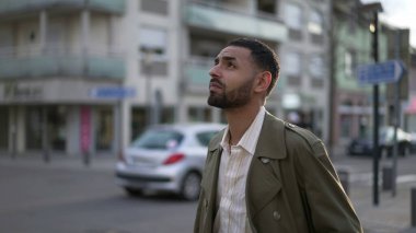 Düşünceli genç bir Arap sokakta ceketle dikiliyor. Dalgın suratlı Faslı bir adamın düşünceli ifadesi.