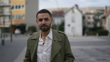 Ortadoğulu bir adamın portresi. Şehir sokağının dışında duruyor.