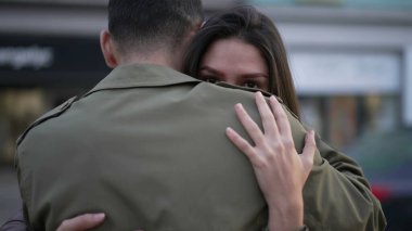 Çiftler sokakta empatik kucaklaşmalarla dururlar. Zor zamanlarda ilgi ve anlayış. Genç adam ve kadın sarılıyor.