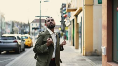 Başarılı Orta Doğulu adam şehir sokaklarındaki başarısını kutluyor, dans ediyor ve kaygısızca eğleniyor.