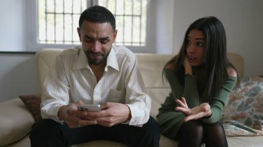 Kız arkadaşı kendini evdeki kanepede ihmal edilmiş hissederken bir adam telefona daldı. Orta Doğulu bir Arap çift