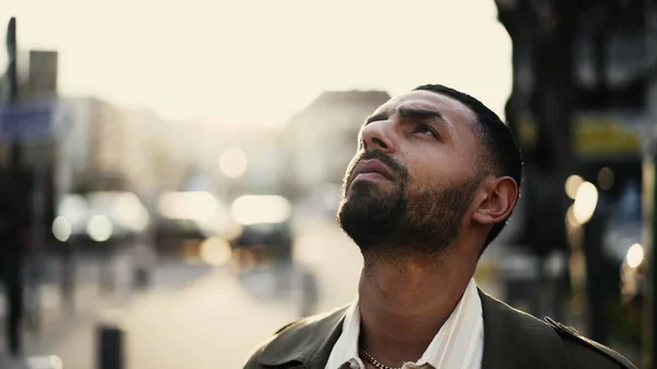 通りに立っているある瞑想的なアラブ人の若者は 空を見て精神的な経験をしています ショットを追跡する都市環境で屋外に立つ中東男性人のクローズアップ顔 — ストック写真