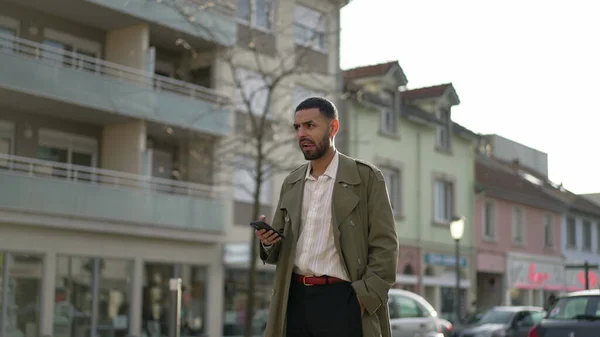 一个忧心忡忡的中东男人站在街上 带着深谋远虑的表情拿着电话 一个深思熟虑的中东思考决策和使用技术 — 图库照片