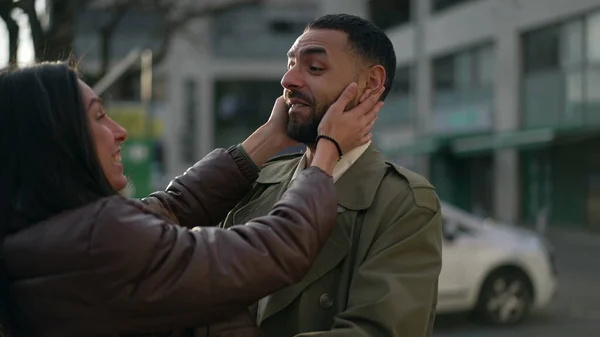Two friends hug and embrace outside, real life happiness reunion. A middle Eastern male and female friend hugging each other in city street. Tracking shot