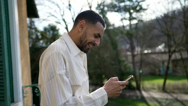 아랍인 청년은 발코니에서 핸드폰으로 소식을 합니다 온라인 콘텐츠알림에 — 스톡 사진