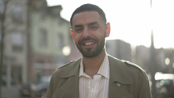 一个中东年轻人站在城市街道上对着摄像机微笑 一名阿拉伯裔摩洛哥男子开心地在运动中被枪击的跟踪 — 图库照片