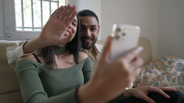 幸せなカップルは 家庭用ソファに座ってスマートフォンデバイスとビデオで家族と話しています 中東アラブの若者と女性 — ストック写真