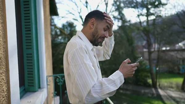 청년은 발코니 밖에서 전화로 소식을 전하는 긍정적 반응을 보이지 않았다 — 스톡 사진